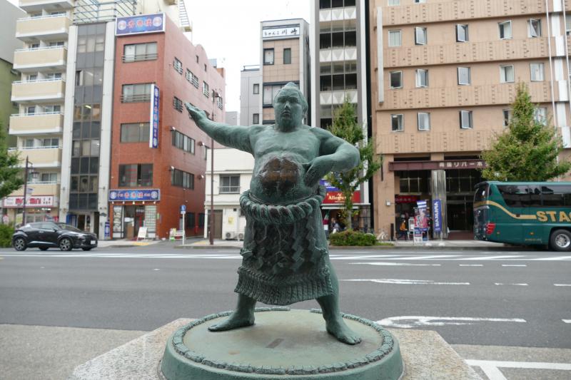Tokio. Centralna część miasta o nazwie Ryogoku.  Uliczna figura zapaśnika sumo